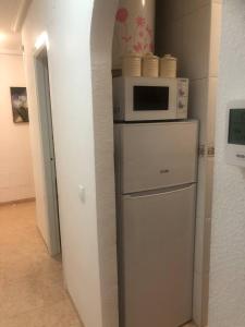 a kitchen with a microwave on top of a refrigerator at Torresal in Torrevieja