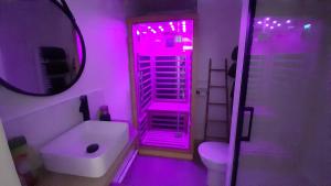 a bathroom with pink lighting and a toilet and a sink at Arty - Premium - Parking box privé - Balcon - Sauna en option in Saint-Priest