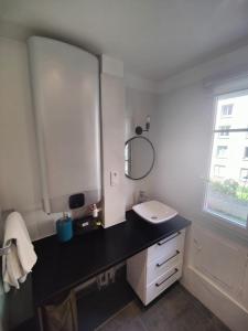 y baño con lavabo y espejo. en Appartement cosy 40m2 - Montmartre, en París