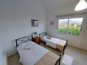 a bedroom with two beds and a window at Villa Agios Georgios with Private Pool in Peyia