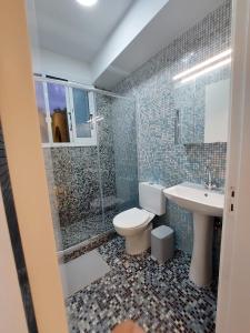a bathroom with a toilet and a sink and a shower at Villa Agios Georgios with Private Pool in Peyia