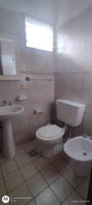 a bathroom with a toilet and a sink at Bowngalos Punta Norte in Federación