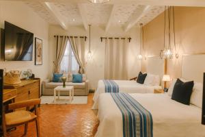 ein Hotelzimmer mit zwei Betten und einer Couch in der Unterkunft Agua Santa Hotel Boutique in San Miguel de Allende + 103 Fotos