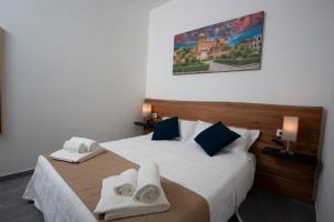 1 dormitorio con 1 cama grande y toallas. en Dimora Les Folies, en Palermo