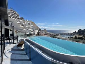 波多黎各的住宿－The One Luxury Apartments，一座海景建筑中的游泳池