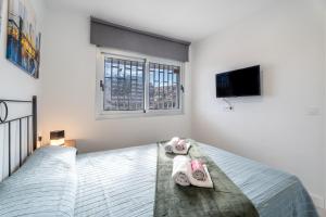 1 dormitorio con 1 cama con toallas y TV en Las Rosas Sunset Apartment, en Arona 20 fotos más
