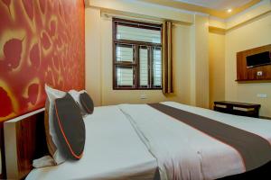 齋浦爾的住宿－OYO Flagship Hotel Mohi Palace，一间卧室设有一张大床和一个窗户。