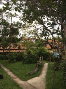 a path in a yard with trees and a house at CARAÍVA House in Caraíva