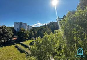 a sun shining on a hill with trees and a building at Balance Room in Sopot