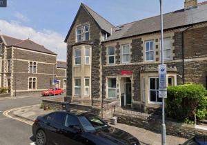 een zwarte auto geparkeerd voor een bakstenen gebouw bij Room with Private Bath in Pontcanna in Cardiff