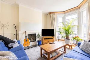 a living room with a blue couch and a table at Room with Private Bath in Pontcanna in Cardiff