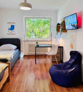 a bedroom with a bed and a desk and a window at Schöne Terrassenwohnung zwischen Giessen und Marburg in Staufenberg