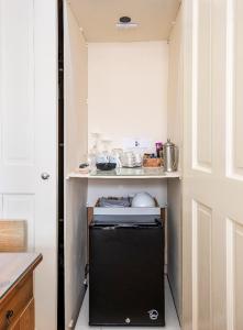 una pequeña cocina con nevera negra. en Room with Private Bath in Pontcanna, en Cardiff