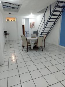 ein Zimmer mit einem Tisch, Stühlen und einer Treppe in der Unterkunft Azul y buenas noches in Orizaba