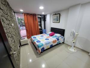 um pequeno quarto com uma cama e uma janela em Espectacular y amplio apartamento amoblado em Barranquilla