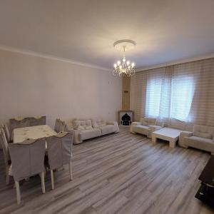 sala de estar con mesa, sillas y lámpara de araña en Family , Fresh , Fascinating, en Baku