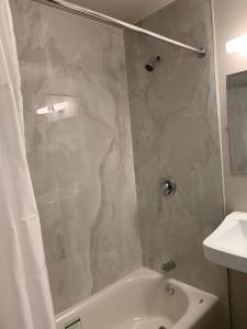 a bathroom with a shower and a tub and a sink at Big 7 Motel in Chula Vista