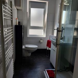 a small bathroom with a toilet and a window at Ferienwohnung Stella Herford in Herford