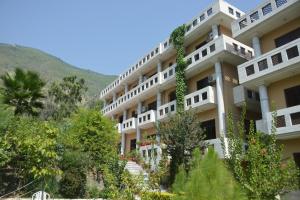 a large white building with trees in front of it at Besham Hilton Hotel, by LMC 