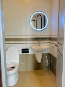 a bathroom with a toilet and a sink and a mirror at HaHe Homestay in Da Lat