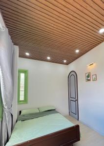 a bedroom with a bed and a wooden ceiling at HaHe Homestay in Da Lat