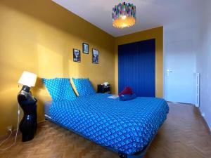 Schlafzimmer mit einem Bett mit blauer Bettwäsche und einer Lampe in der Unterkunft Panoramic Sea view - Balcony - Tramway - 2 Bedrooms - Wifi - Fully equipped kitchen in Nizza