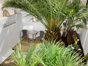 a room with two chairs and a table and palm trees at Brighton Palms in Brighton & Hove