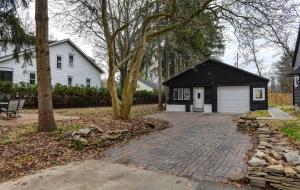 een huis met een garage en een stenen oprit bij Clintonville Bungalow Under The Pines in Columbus