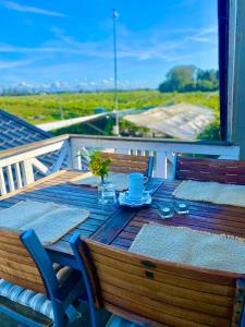 a wooden table with a plate of food on a balcony at Cozy Rooms at Organic Vinery, Vesterhave Vingaard - see more at BY-BJERG COM in Karrebæksminde