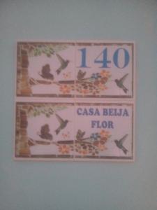 a sign on a wall with a clock on it at Casa Beija Flor in São Thomé das Letras