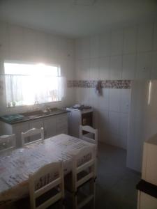a kitchen with a table and chairs in a room at Casa Beija Flor in São Thomé das Letras