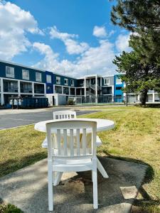 a white table and a white chair in front of a building at BlissPoint Inn Northwest Indianapolis in Indianapolis