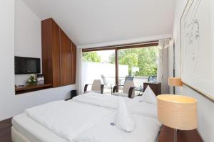 a bedroom with two white beds and a television at Romantik Hotel Johanniter-Kreuz in Überlingen