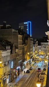 une ville la nuit avec des voitures qui descendent dans une rue dans l'établissement Little Stephanie, à Bruxelles