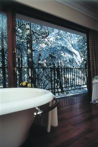 a bathroom with a sink and a window with snow at Wildflower Hall, An Oberoi Resort, Shimla in Shimla