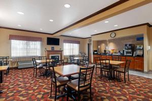 a restaurant with tables and chairs and a bar at Best Western Laramie Inn & Suites in Laramie