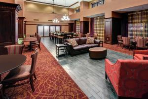 a lobby with couches and tables and a dining room at Hampton Inn & Suites Chadds Ford in Glen Mills