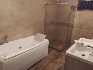 ein Badezimmer mit einer Dusche, einer Badewanne und einem Waschbecken in der Unterkunft Casa Carambolo in Cali