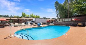 a swimming pool in a patio with tables and umbrellas at Best Western Amador Inn in Jackson