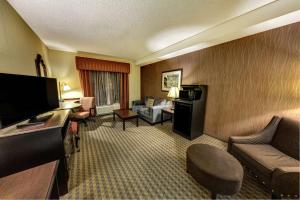 a hotel room with a couch and a television at Hampton Inn & Suites Chadds Ford in Glen Mills