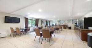 a dining room with tables and chairs and a flat screen tv at Best Western Amador Inn in Jackson
