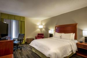 a hotel room with a bed and a desk and a television at Hampton Inn Bowling Green KY in Bowling Green