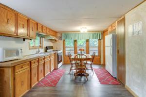 a kitchen with a table and a white refrigerator at Waterfront Wahkon Home with Wraparound Deck and Docks in Isle