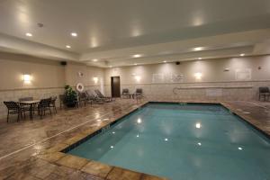 a swimming pool in a hotel with tables and chairs at Hilton Garden Inn Findlay in Findlay