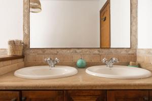 a bathroom counter with two sinks and a mirror at La Casita del Sol in Soo