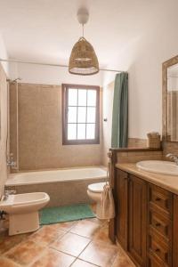 a bathroom with a tub and a toilet and a sink at La Casita del Sol in Soo +4 photos