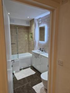 uma casa de banho com uma banheira, um lavatório e um WC. em leigh Penthouse Apartment em Leigh-on-Sea