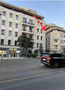 a black car driving down a street in front of a building at Hotel type rooms on avenue Melikishvili, city center in Tbilisi City