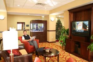 un hombre sentado en una silla en una habitación de hotel en Hampton Inn Dade City - Zephyr Hills, en Dade City