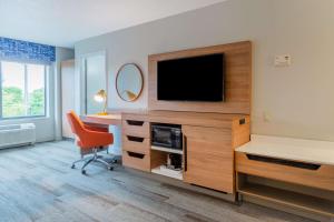 Cette chambre dispose d'une télévision, d'un bureau et d'une chaise. dans l'établissement Hampton Inn La Crosse/Onalaska, à Onalaska